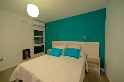 a bedroom with a large white bed with blue walls at Complejo Entre Marte y La Luna in Merlo