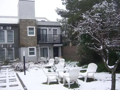 a group of white chairs and tables in the snow at Complejo Entre Marte y La Luna in Merlo