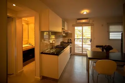 a kitchen with white cabinets and a table and chairs at Complejo Entre Marte y La Luna in Merlo