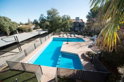 a large swimming pool in a yard with a palm tree at Complejo Entre Marte y La Luna in Merlo