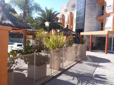 a sidewalk with plants and a fence in front of a building at Hotel Mónaco in Villa Carlos Paz