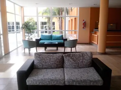 a living room with a couch and a table at Hotel Mónaco in Villa Carlos Paz