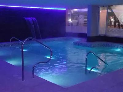 a swimming pool with blue lights in a house at Hotel Mónaco in Villa Carlos Paz