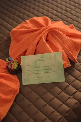 an orange blanket with a piece of paper on it at Hotel Mónaco in Villa Carlos Paz