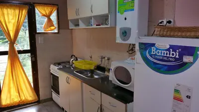 a small kitchen with a sink and a refrigerator at Cabañas Inti Wara in Los Reartes
