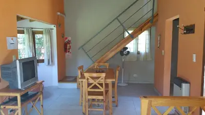 a living room with a tv and a table with a tv at Cabañas Inti Wara in Los Reartes