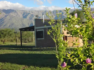 a small house with mountains in the background at La Maína Cabañas in San Javier
