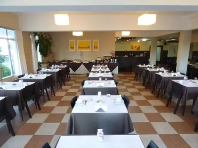 a room filled with tables and chairs in a restaurant at Hotel Linz in Villa Carlos Paz
