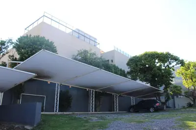 a building with a car parked under a canopy at Hotel Linz in Villa Carlos Paz