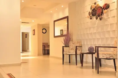 a hallway with chairs and a table and a mirror at Hotel Linz in Villa Carlos Paz