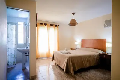 a bedroom with a bed and a bathroom with a sink at Carlos Paz Departamentos in Villa Carlos Paz