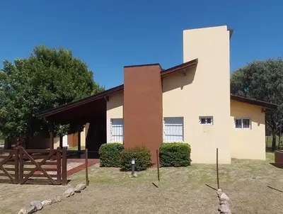 a building with a gate and a fence in front of it at Cabañas Ayres de Sierra in Los Reartes