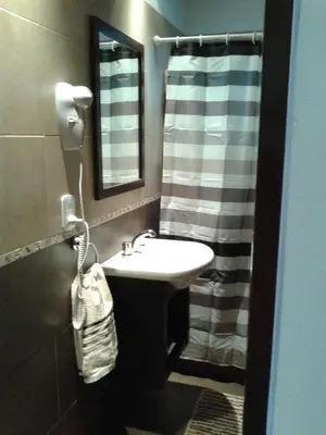 a bathroom with a sink and a shower curtain at Cabañas Ayres de Sierra in Los Reartes