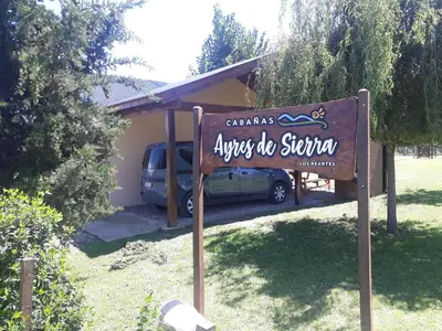 a sign in front of a house with a car at Cabañas Ayres de Sierra in Los Reartes