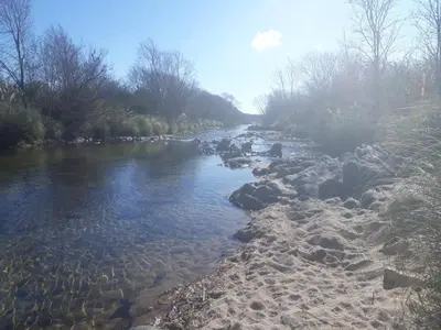 a river with some rocks in the water at Cabañas Ayres de Sierra in Los Reartes