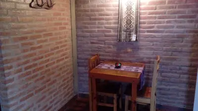 a small table in a room with a brick wall at Alto Valle Cabañas de Montaña in Mina Clavero