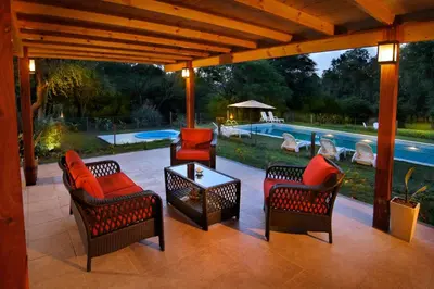 a patio with chairs and a table and a pool at La Faustina Casas de Campo in Villa General Belgrano