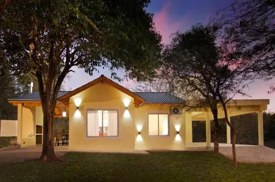 a small yellow house with lights on it at La Faustina Casas de Campo in Villa General Belgrano