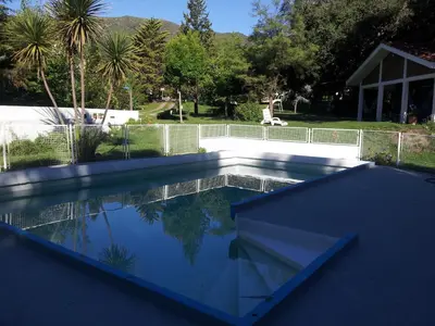 a swimming pool in a yard with a fence at Villa Verde Posada in Bialet Massé