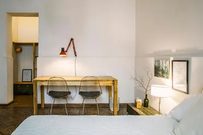 a bedroom with a bed and a desk with two chairs at Casa Helsinki in Cordoba