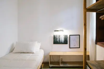 a small bedroom with a bed and a table at Casa Helsinki in Cordoba