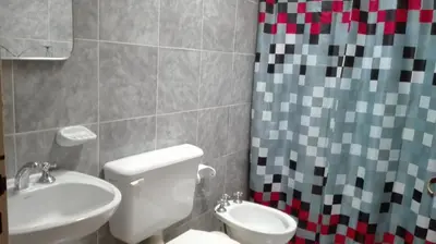 a bathroom with a toilet and a sink and a shower curtain at Nuestro Rinconcito in Villa Cura Brochero