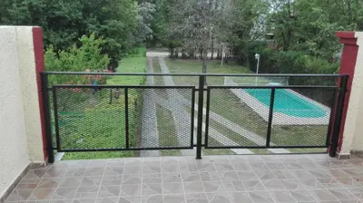 a metal gate with a view of a pool at Nuestro Rinconcito in Villa Cura Brochero