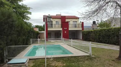 a house with a swimming pool in front of a house at Nuestro Rinconcito in Villa Cura Brochero