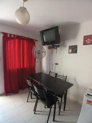 a dining room with a black table and chairs and a television at Nuestro Rinconcito in Villa Cura Brochero