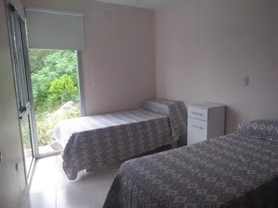 a hotel room with two beds and a window at lacasonavistalago in Villa Carlos Paz
