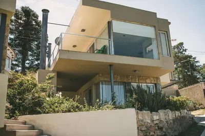 a house with a balcony and stairs in front of it at lacasonavistalago in Villa Carlos Paz
