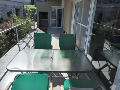 a glass table and chairs on a patio at lacasonavistalago in Villa Carlos Paz