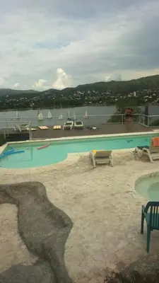a swimming pool with a view of a body of water at lacasonavistalago in Villa Carlos Paz