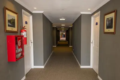 a long hallway with gray walls and a red vending machine at Howard Johnson Rio Cuarto Hotel y Casino in Río Cuarto