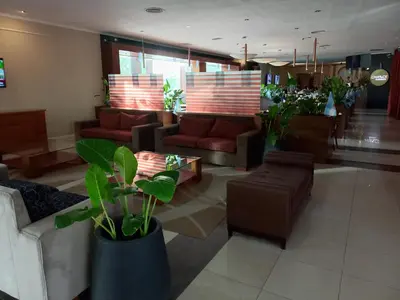a lobby with couches and plants in a room at Howard Johnson Rio Cuarto Hotel y Casino in Río Cuarto