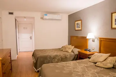 a hotel room with two beds and a hallway at Howard Johnson Rio Cuarto Hotel y Casino in Río Cuarto