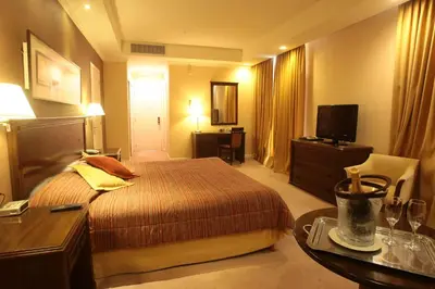 a hotel room with a bed and a table at Howard Johnson Sierras Hotel y Casino Alta Gracia in Alta Gracia