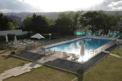 a large swimming pool with umbrellas and chairs at Howard Johnson Sierras Hotel y Casino Alta Gracia in Alta Gracia