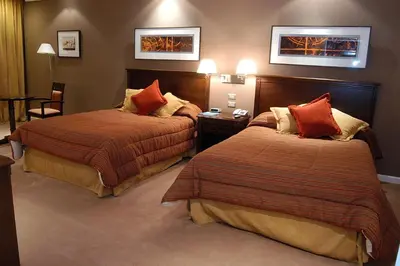 a hotel room with two beds with red pillows at Howard Johnson Sierras Hotel y Casino Alta Gracia in Alta Gracia