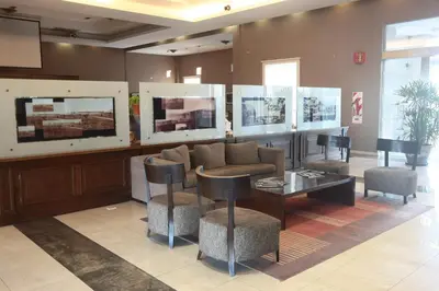 a lobby with a couch and a table and chairs at Howard Johnson Sierras Hotel y Casino Alta Gracia in Alta Gracia