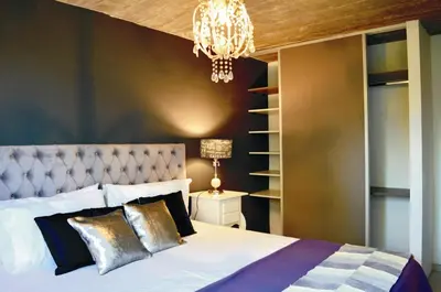 a bedroom with a large bed and a chandelier at Lago Manso in Potrero de Garay