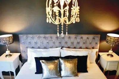 a bedroom with a large bed with a chandelier at Lago Manso in Potrero de Garay