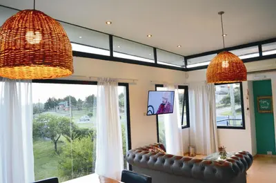a living room with a couch and a large window at Lago Manso in Potrero de Garay