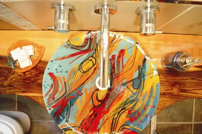 a close up of a bathroom sink with a painting on it at Lago Manso in Potrero de Garay