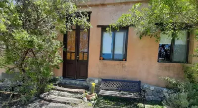 a house with a bench in front of a building at Los Remolinos in Merlo