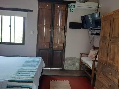 a bedroom with a bed and a tv and a chair at Los Remolinos in Merlo