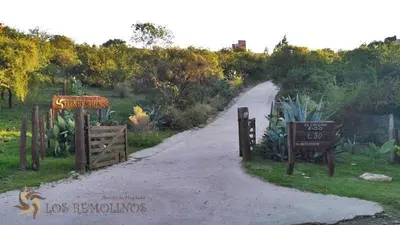 a dirt road with a gate and a sign at Los Remolinos in Merlo
