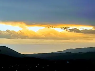 a sunset over the mountains with the sun setting at Sierras Del Sol in Villa Carlos Paz