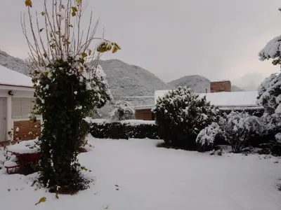 a yard covered in snow with mountains in the background at Sierras Del Sol in Villa Carlos Paz