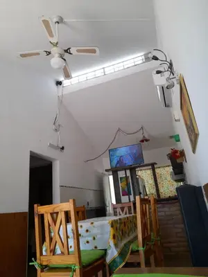 a room with a bed and two chairs and a ceiling fan at Sierras Del Sol in Villa Carlos Paz